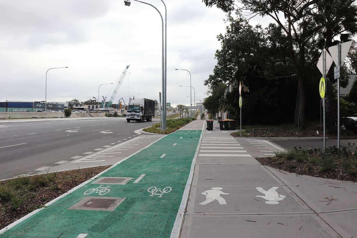 A green bicycle lane beside a shared path and a road in Sydney